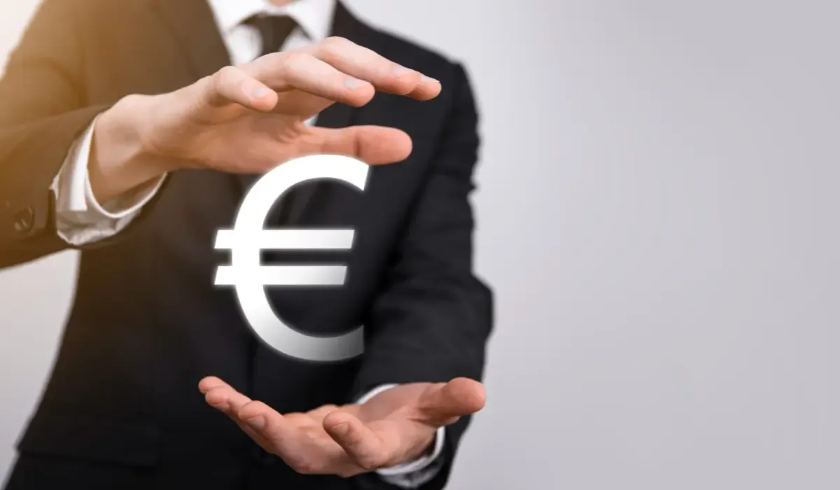 Business professional holding a glowing euro symbol between open hands, representing secure currency exchange, euro transfers, and financial management solutions.