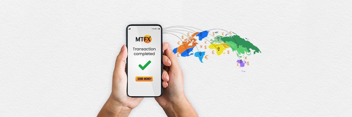Hands holding a smartphone showing an MTFX transaction completed screen, with global currency symbols and payment paths connecting across a colorful world map.