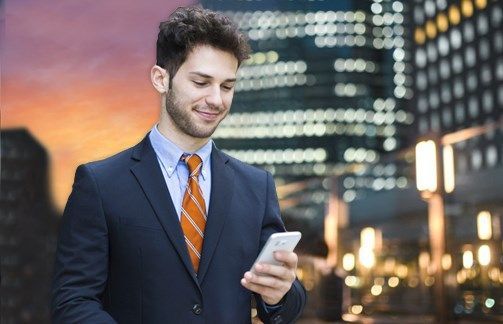 Business professional using a smartphone in a city setting, with a checklist overlay highlighting international payment use cases such as supplier payments, travel and tourism, property purchase, and study abroad expenses.