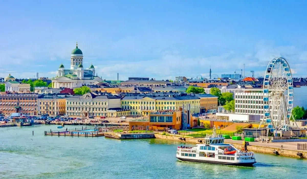 Scenic view of Helsinki waterfront featuring the Helsinki Cathedral, ferris wheel, and harbor in Finland.