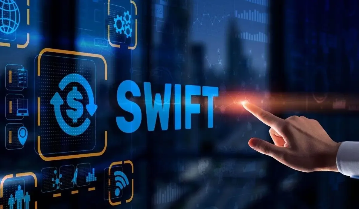 Digital illustration of the SWIFT payment system with icons and a hand pointing to the word "SWIFT" on a virtual screen.