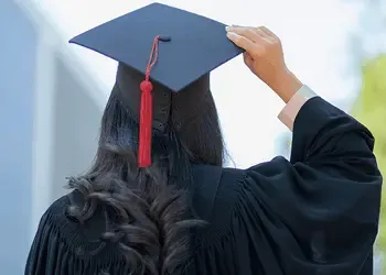 Graduate in cap and gown, symbolizing successful international tuition payments.