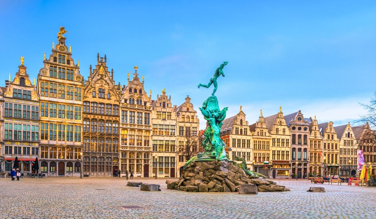 Historic guild houses and the Brabo Fountain at the Grote Markt (main square) in Antwerp, Belgium, during a sunny day.