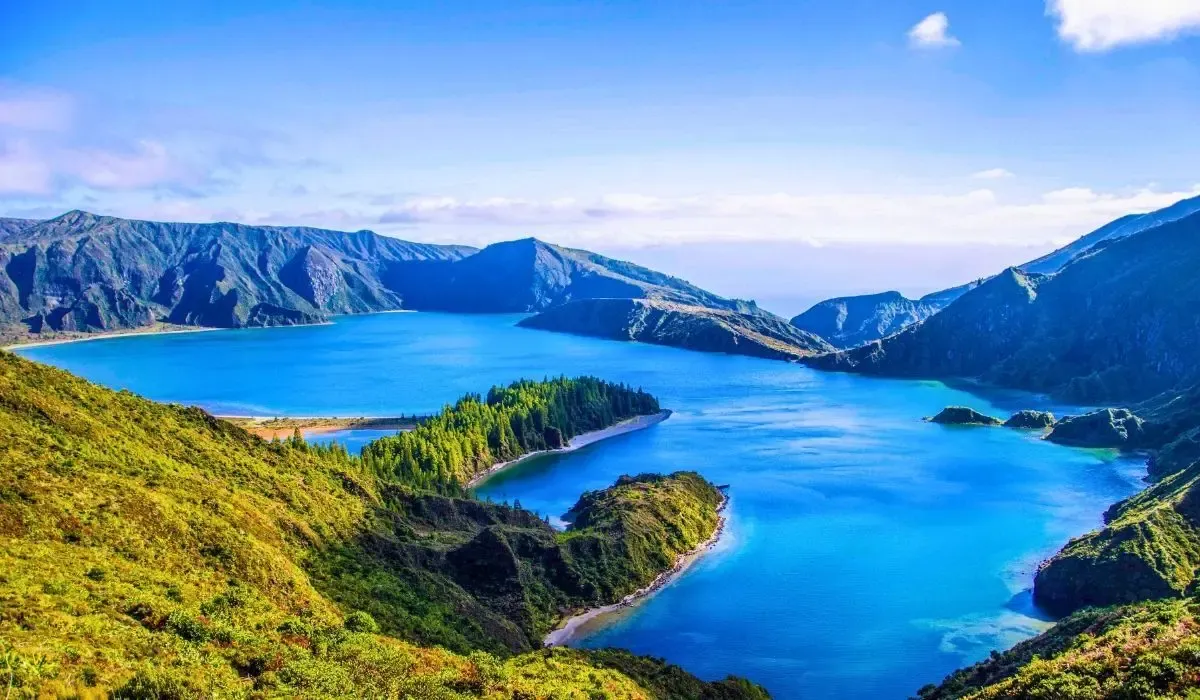 Stunning volcanic lake and lush green hills in the Azores, Portugal, under clear blue skies. Canadians buying property in Portugal can enjoy competitive CAD to EUR conversions and affordable cross-border payment services with MTFX.