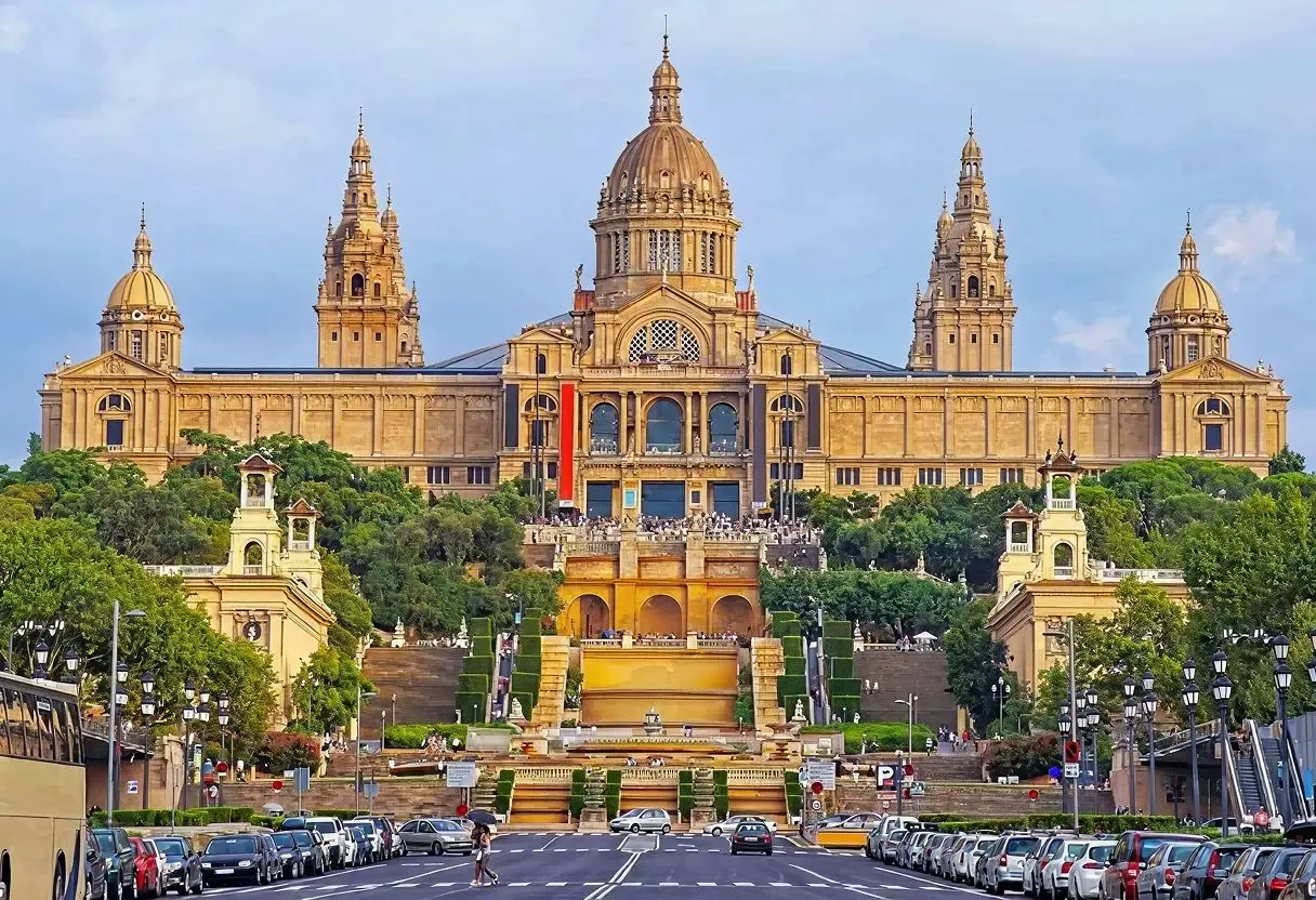 he grand façade of the National Palace in Barcelona, Spain, viewed from a bustling avenue lined with cars and trees. Canadians interested in buying property in Spain can secure better CAD to EUR exchange rates and low-cost international transfers to facilitate their real estate investments.