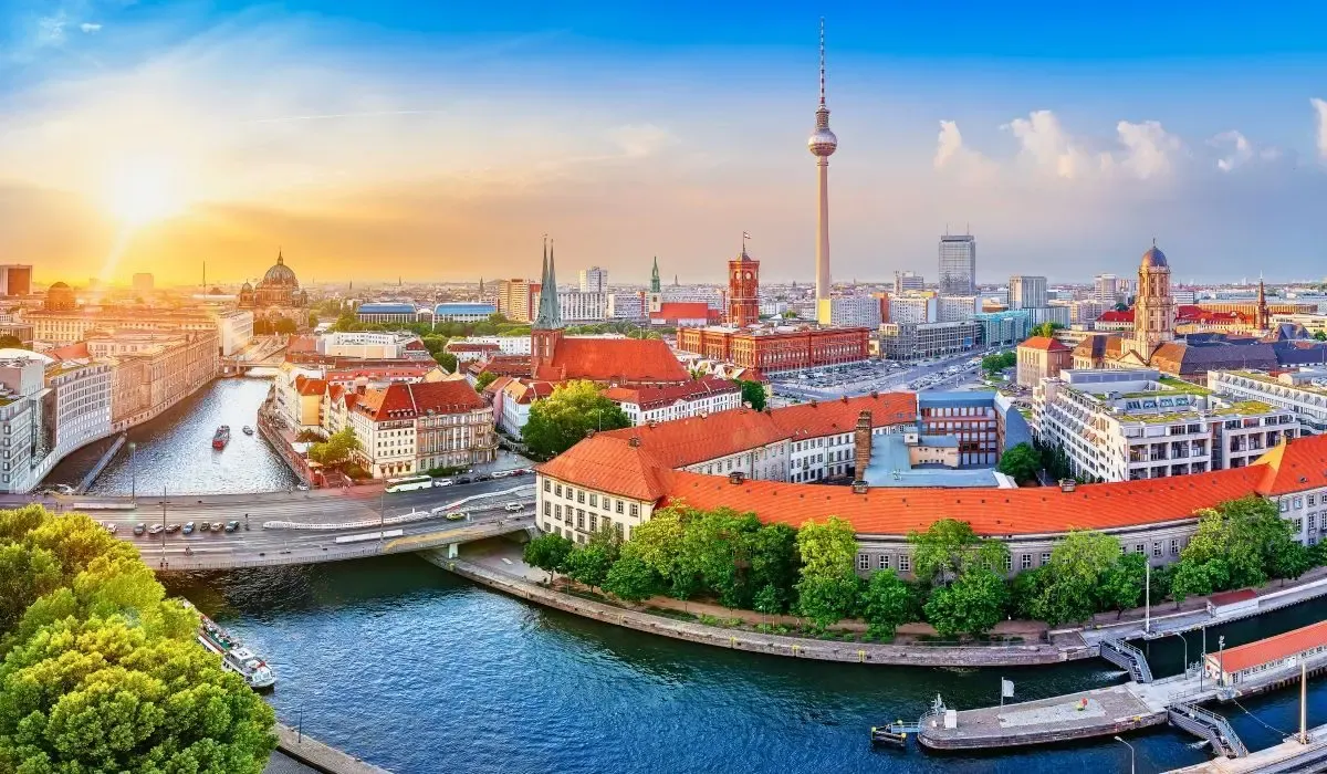 Panoramic view of Berlin skyline with river Spree and iconic TV Tower at sunset, ideal for Canadians buying property in Germany and converting CAD to EUR at competitive rates.