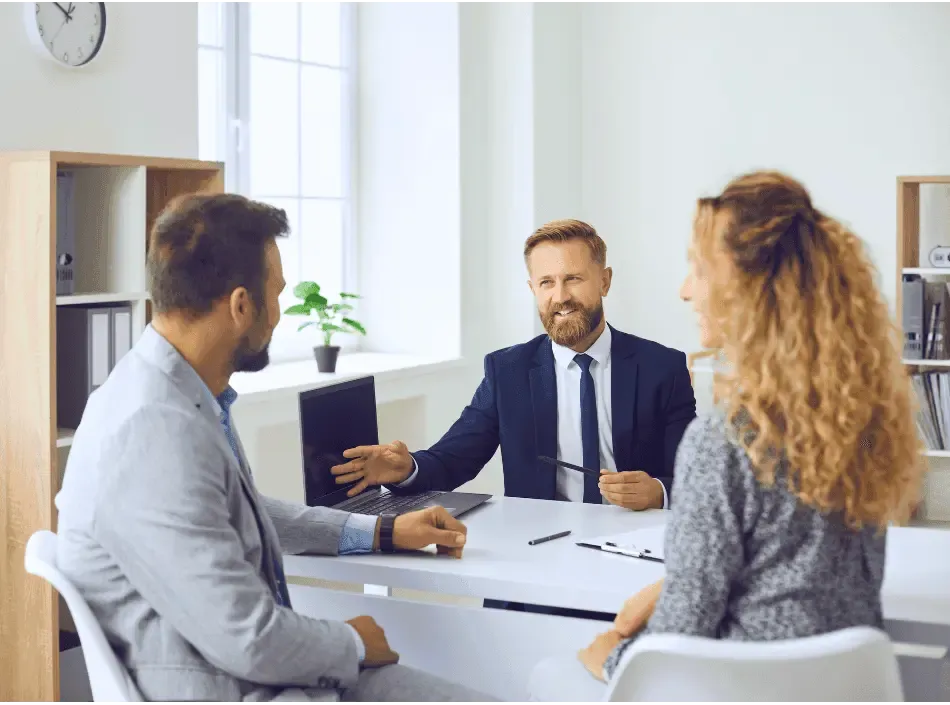 Professional advisor meeting with a couple at a desk in a modern office, representing expert guidance for international property purchases or financial planning