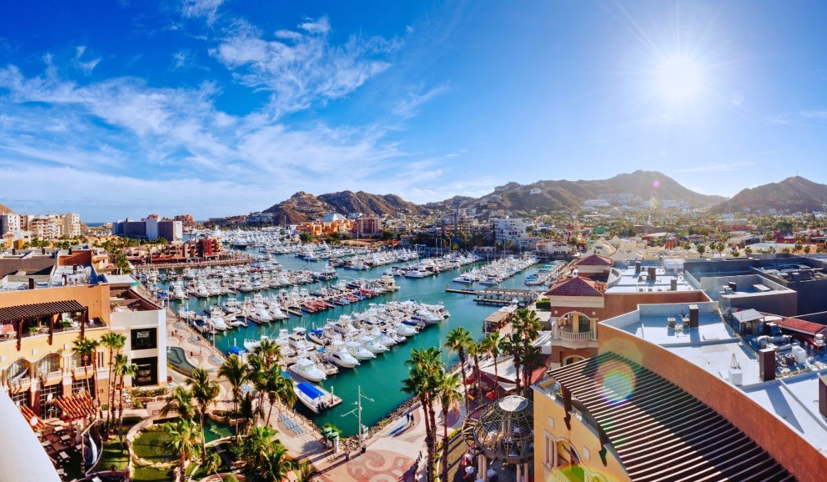 A scenic view of Cabo San Lucas's iconic El Arco rock formation, with boats navigating the surrounding blue waters.​