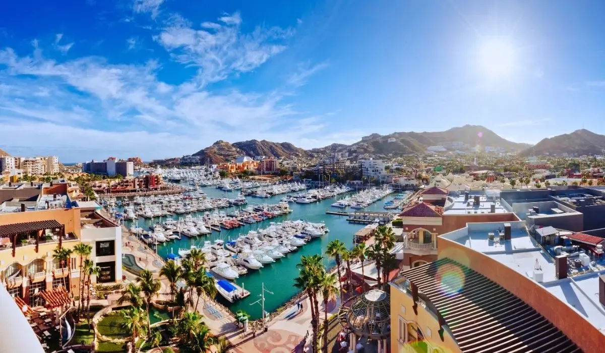 Cabo San Lucas marina filled with boats and surrounded by resorts, a prime Mexican real estate market where Canadians can buy property and convert CAD to MXN with low fees and fast settlement.