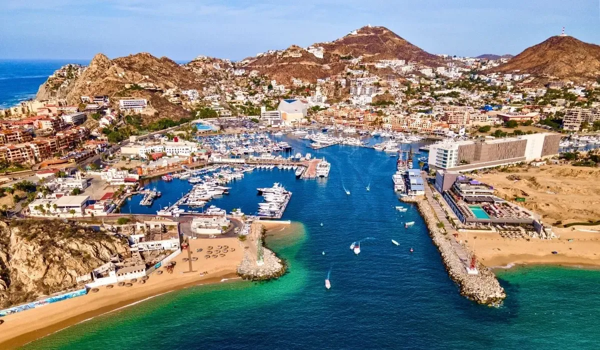A scenic image of Cabo San Lucas showcasing the iconic El Arco rock formation jutting out into the sea, with clear blue waters and a bright sky.