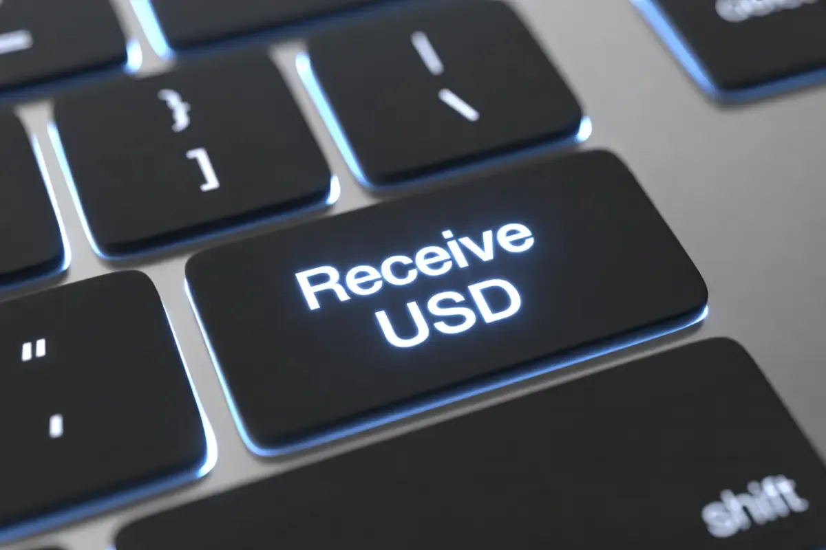 Close-up of a glowing keyboard key labeled “Receive USD,” symbolizing digital international payments and the ability to receive U.S. dollars online.