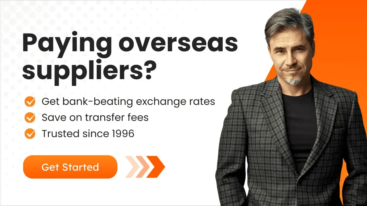 A promotional banner featuring a professional-looking man in a plaid suit with the text 'Paying overseas suppliers? Get bank-beating exchange rates, save on transfer fees, trusted since 1996.'