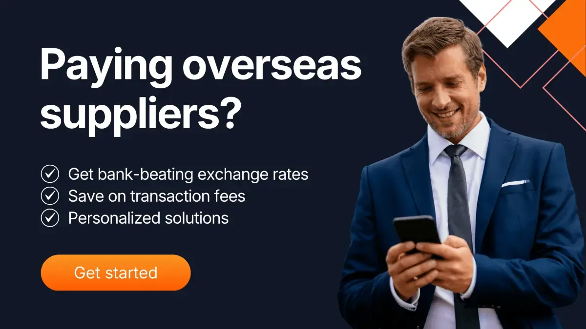 Business professional in a suit smiling while checking his phone, with text promoting MTFX supplier payments highlighting bank-beating exchange rates, low transaction fees, and personalized solutions.
