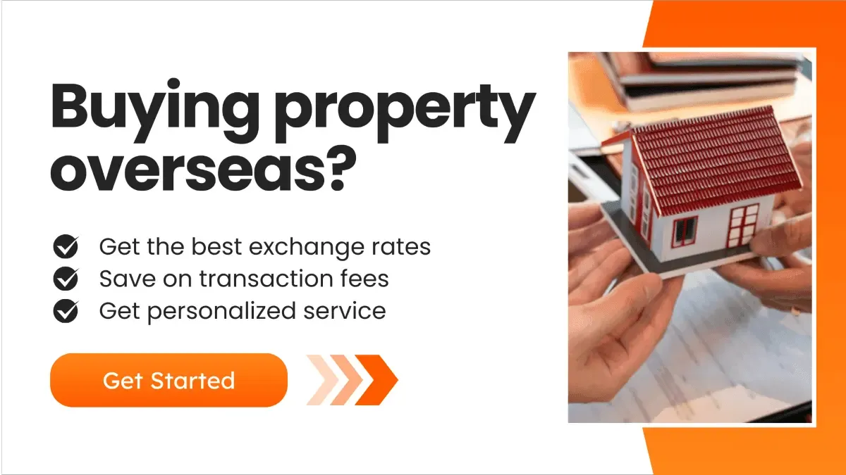 Hands holding a model house over paperwork, representing international real estate transactions and foreign property purchases with better exchange rates and lower transfer fees.