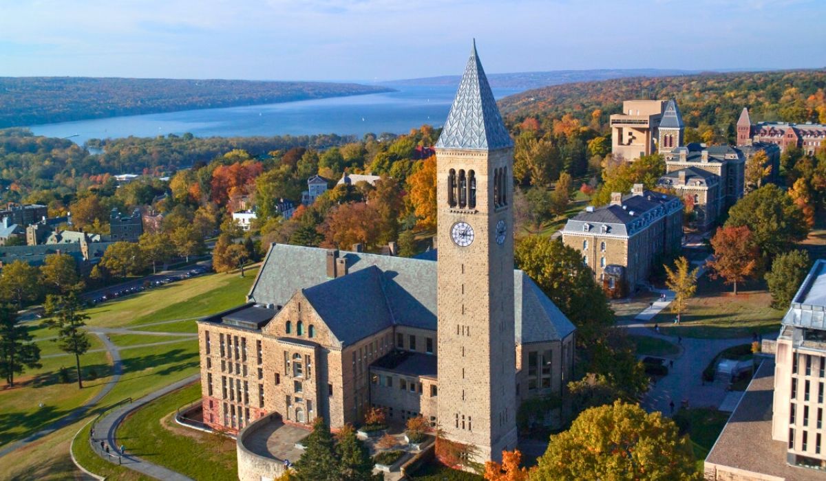 Scenic aerial view of Cornell University’s McGraw Tower and historic campus buildings, set amidst colorful fall trees overlooking Cayuga Lake.