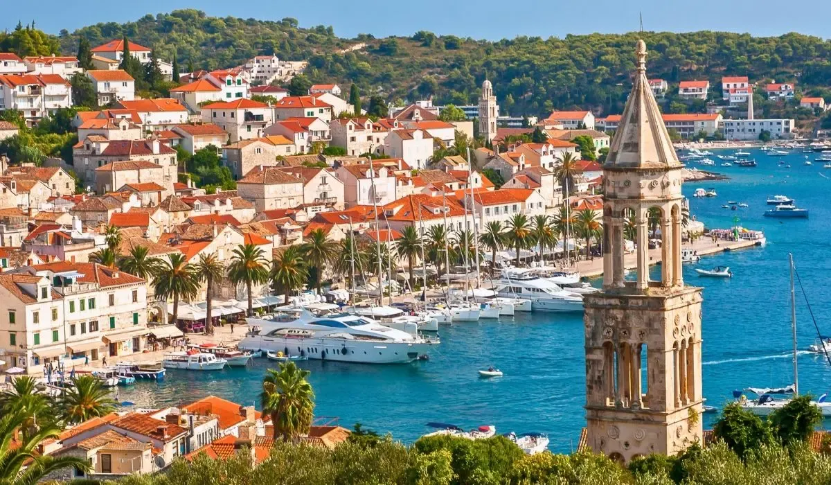 An aerial shot of Dubrovnik, Croatia, highlighting the city's medieval walls, terracotta rooftops, and the Adriatic Sea.