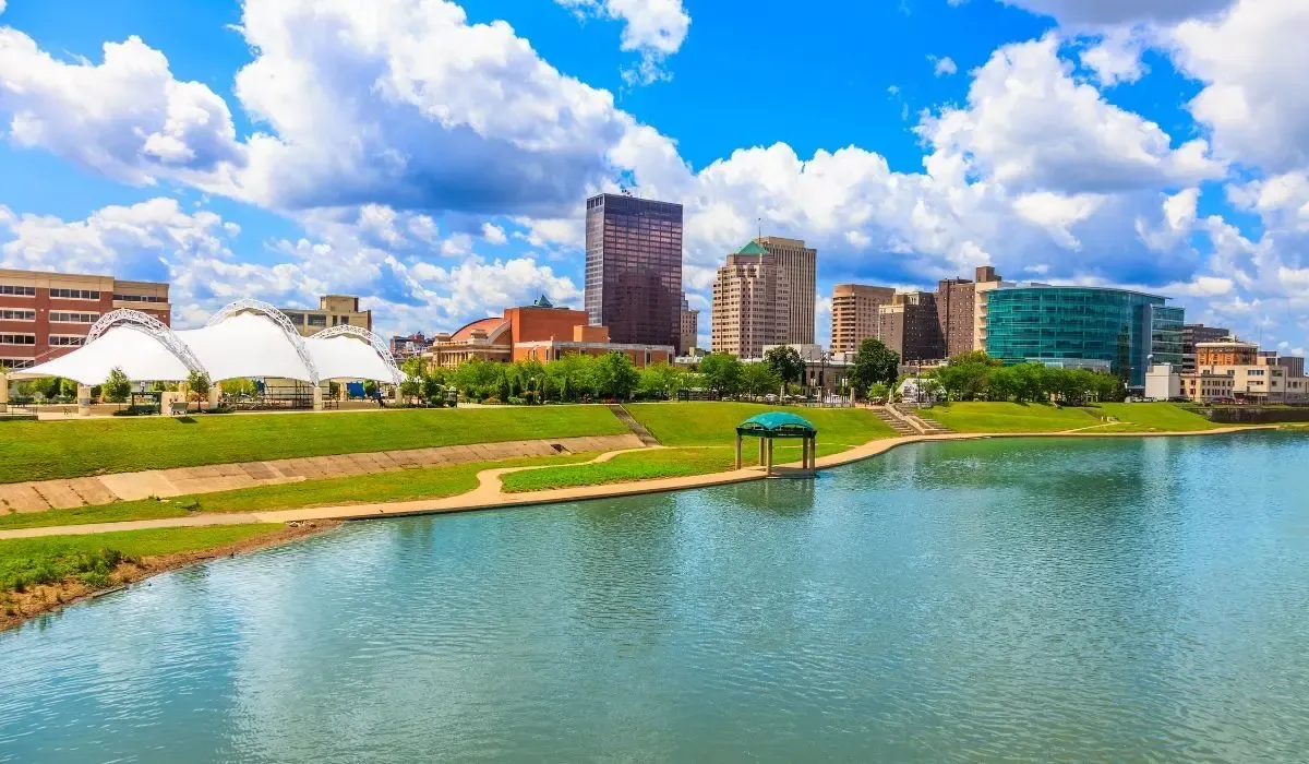 A lively image of Daytona Beach's shoreline, featuring sunbathers, beach umbrellas, and the famous Daytona Beach Pier extending into the Atlantic Ocean.