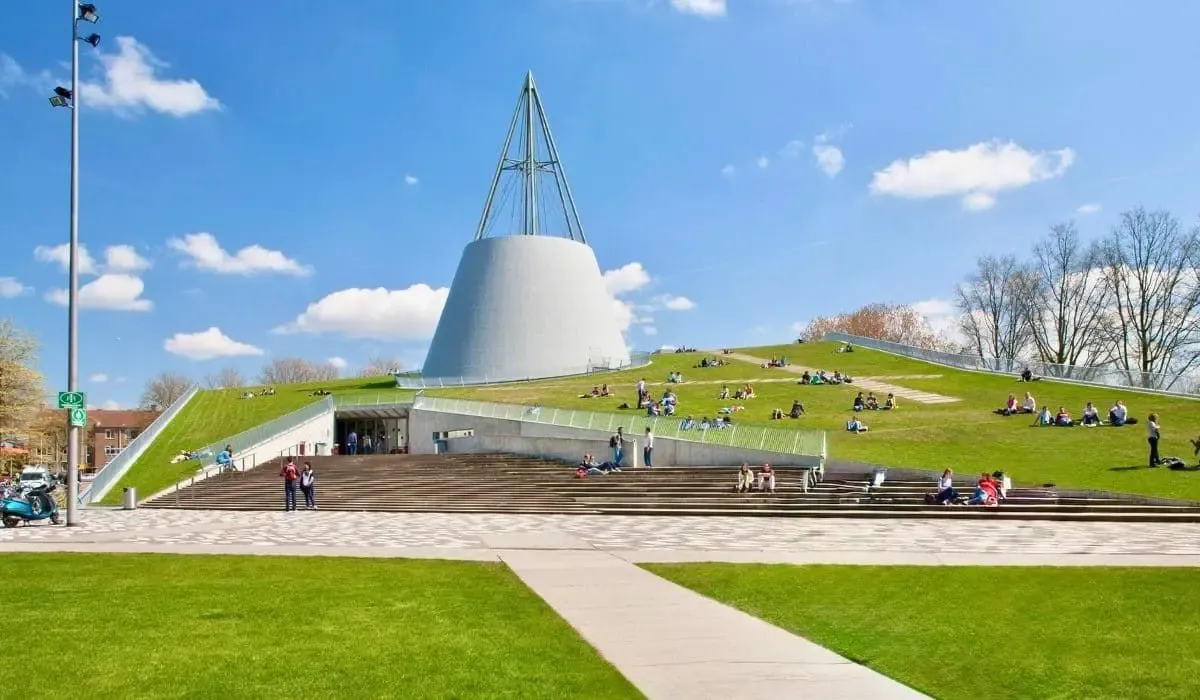 The cone shaped library at TU Delft with students relaxing on the grass. MTFX offers Canadian students a secure and low cost way to pay EUR tuition from Canada.