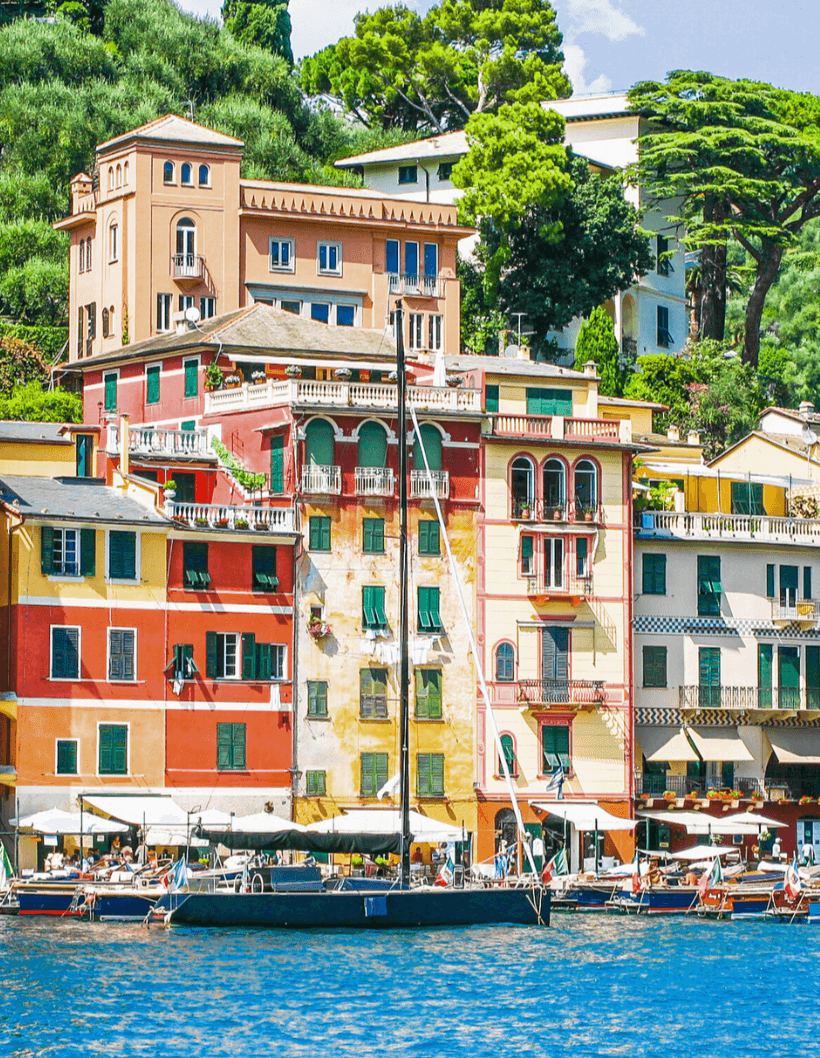 Colorful waterfront buildings in a scenic European coastal town, with boats docked along the shoreline—ideal for showcasing European property investment opportunities.