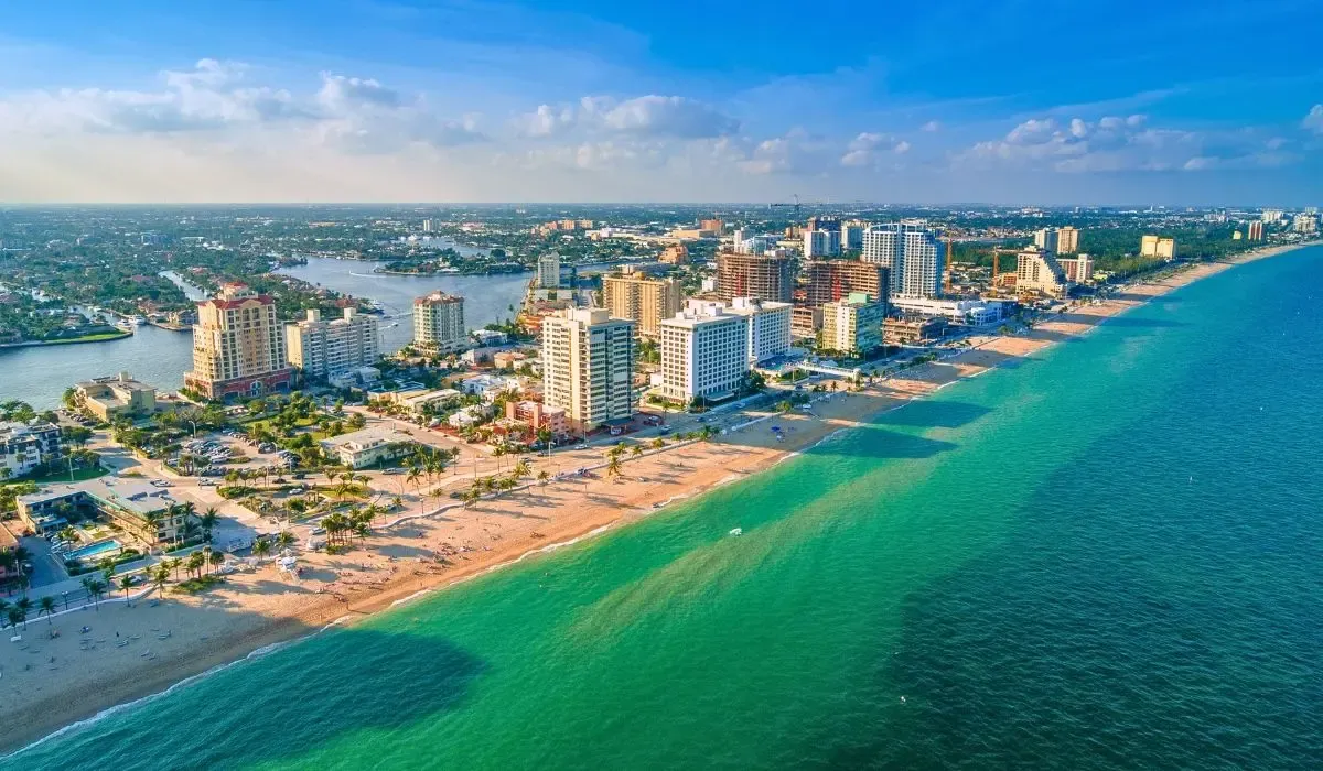 A vibrant image of Fort Lauderdale's beachfront with boats docked along the Intracoastal Waterway and high-rise condos in the background.