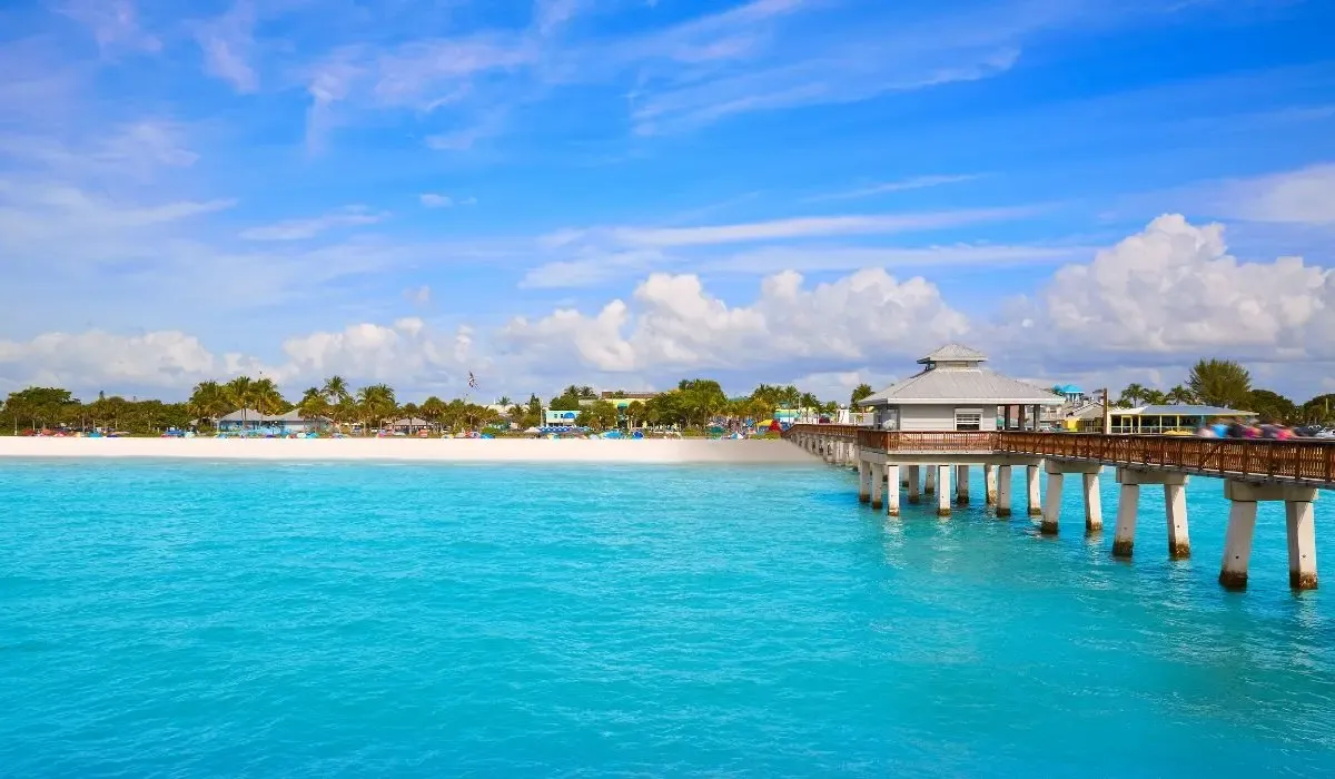 An aerial view of Fort Myers featuring the Caloosahatchee River, downtown buildings, and lush greenery.