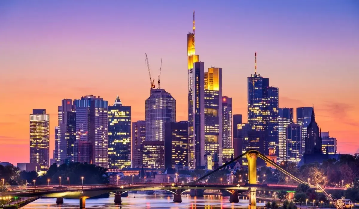 Dramatic twilight skyline of Frankfurt, Germany with illuminated skyscrapers reflecting on the Main River. Canadians looking to purchase property in Germany can leverage favourable CAD to EUR rates and cost-effective transfers via MTFX.