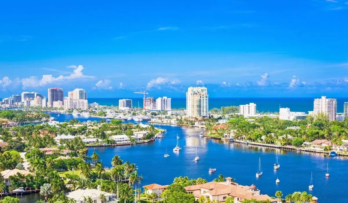 Skyline of Fort Lauderdale, Florida, featuring waterways, high-rise buildings, yachts, and ocean horizon. Canadians investing in property in Fort Lauderdale can achieve strong CAD to USD rates and reduced transfer fees with MTFX.