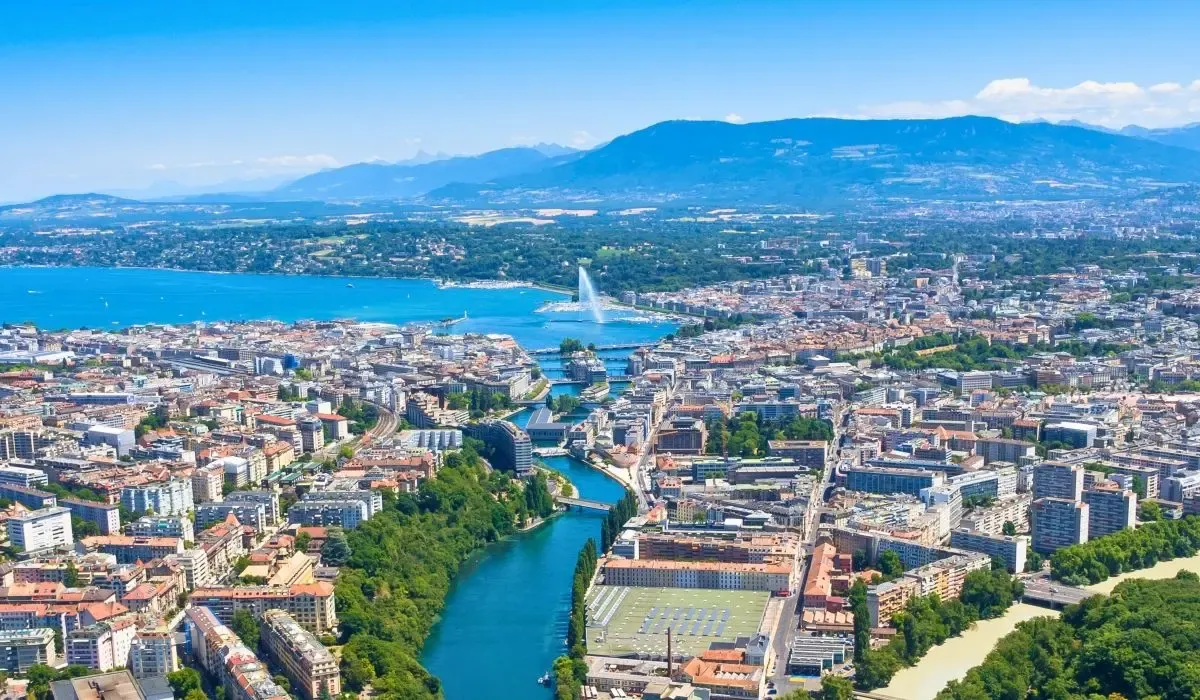 Aerial view of Geneva, Switzerland showing the sparkling Jet d’Eau fountain and the city nestled between Lake Geneva and surrounding mountains. Canadians looking to buy property in Switzerland can enjoy competitive CAD to CHF rates and low fees with MTFX.