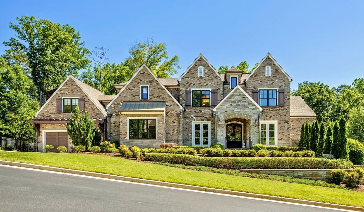 Traditional brick home in suburban Georgia with manicured lawn and large windows.