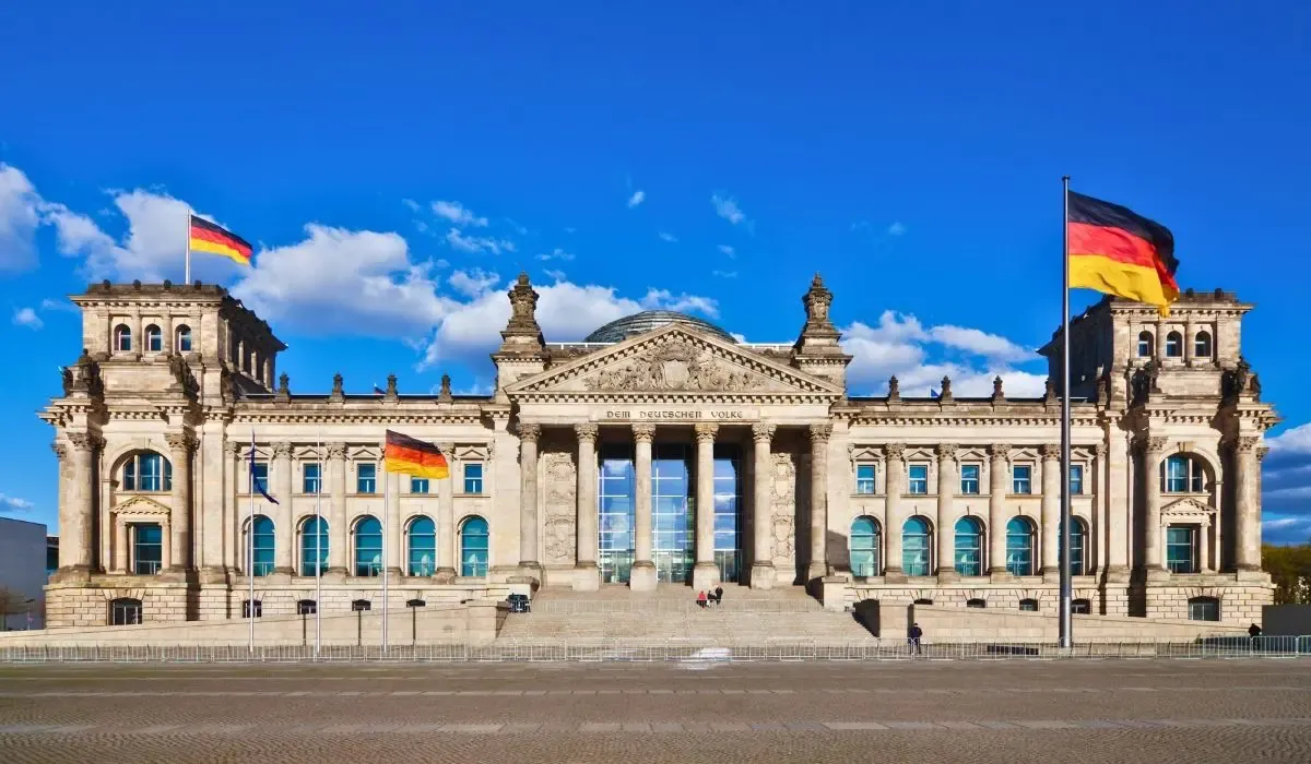 An image of Berlin's Brandenburg Gate illuminated at dusk, with people gathered around, symbolizing Germany's rich history and modern culture.