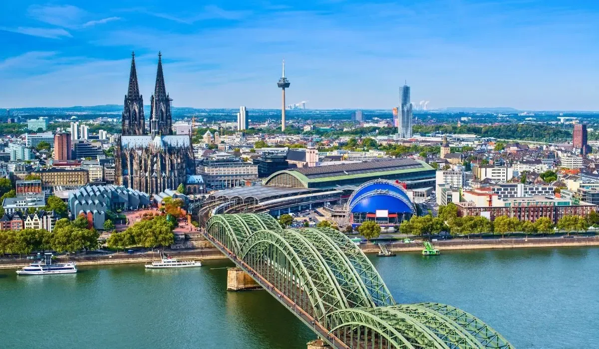 An image of Berlin's Brandenburg Gate illuminated at dusk, with people gathered around, symbolizing Germany's rich history and modern culture.​