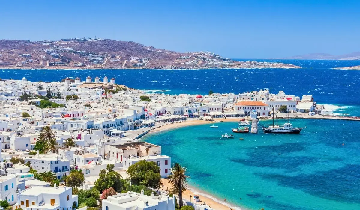 A picturesque image of Santorini, Greece, showcasing whitewashed buildings with blue domes perched on cliffs overlooking the Aegean Sea.