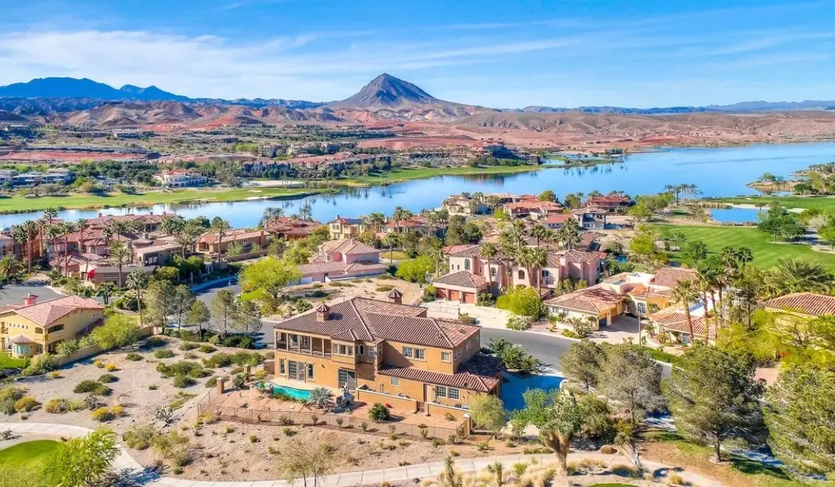 An aerial view of Henderson displaying suburban homes, green spaces, and the backdrop of desert hills.