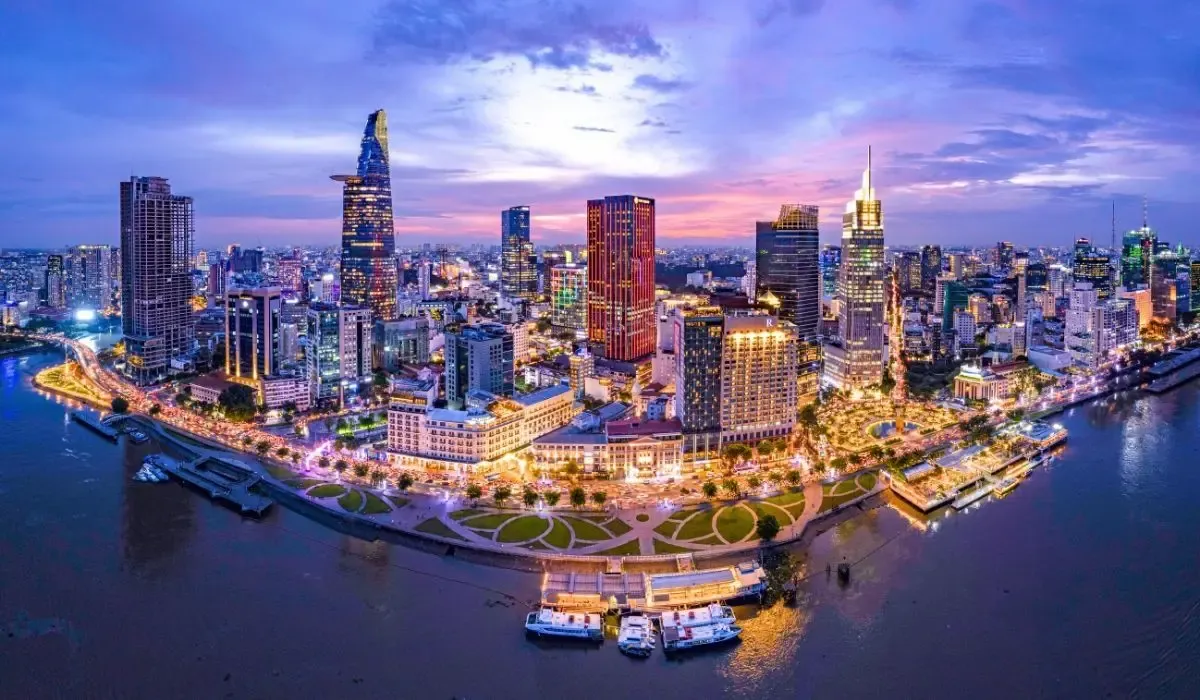 A vibrant street scene in Ho Chi Minh City, featuring bustling markets, motorbikes, and French colonial architecture amidst tropical greenery.