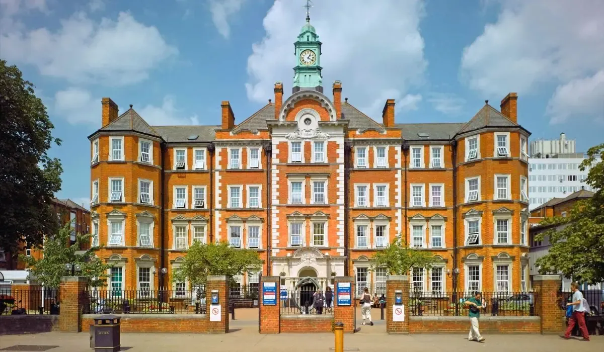 Imperial College London’s historic red-brick and white-trimmed Queen’s Tower campus building with students outside.
