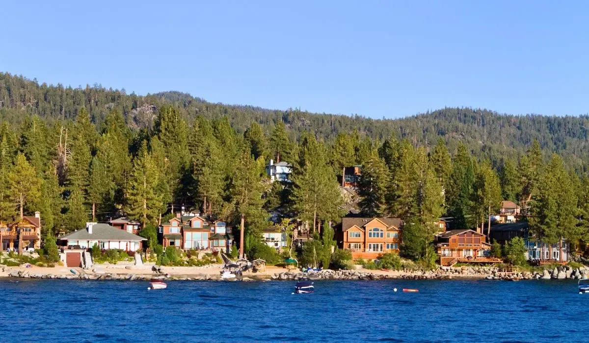 A picturesque view of Lake Tahoe with crystal-clear waters, pine-covered shores, and snow-capped mountains in the distance.