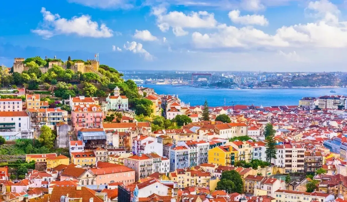 Lisbon’s historic cityscape with São Jorge Castle and the Tagus River under a bright sky, depicting the financial process of sending large sums from Canada to Portugal and the importance of securing favorable FX rates when investing in Portuguese property.