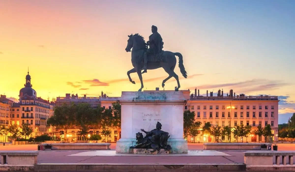 Equestrian statue of Louis XIV in Lyon’s Place Bellecour at sunset, surrounded by historic architecture under glowing skies. Canadians exploring property purchases in France can maximize CAD to EUR rates and save on transfer fees using MTFX.