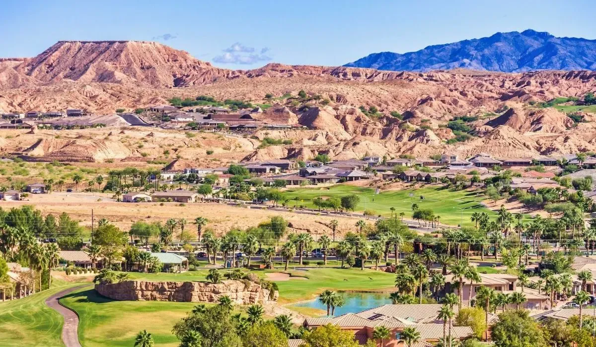 A scenic landscape of Mesquite featuring desert terrain, residential neighborhoods, and surrounding mountains under a clear blue sky.