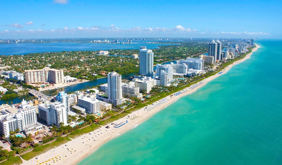 A panoramic view of Miami's skyline featuring modern high-rise buildings along the waterfront under a clear blue sky.