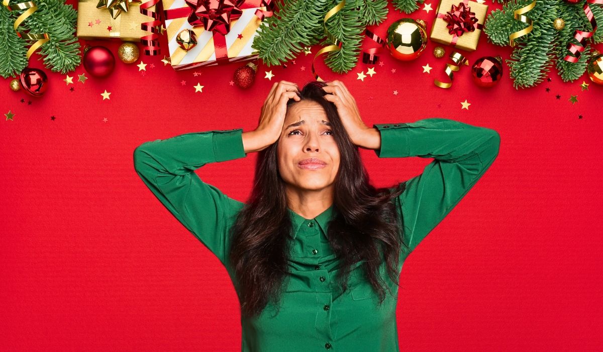 Hero image visual featuring Christmas decorations and a worried woman with both hands on her head wearing a green dress.