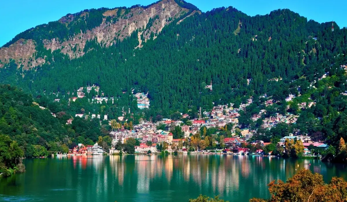 Peaceful view of Nainital, Uttarakhand, with its lake surrounded by forested hills and colorful houses.