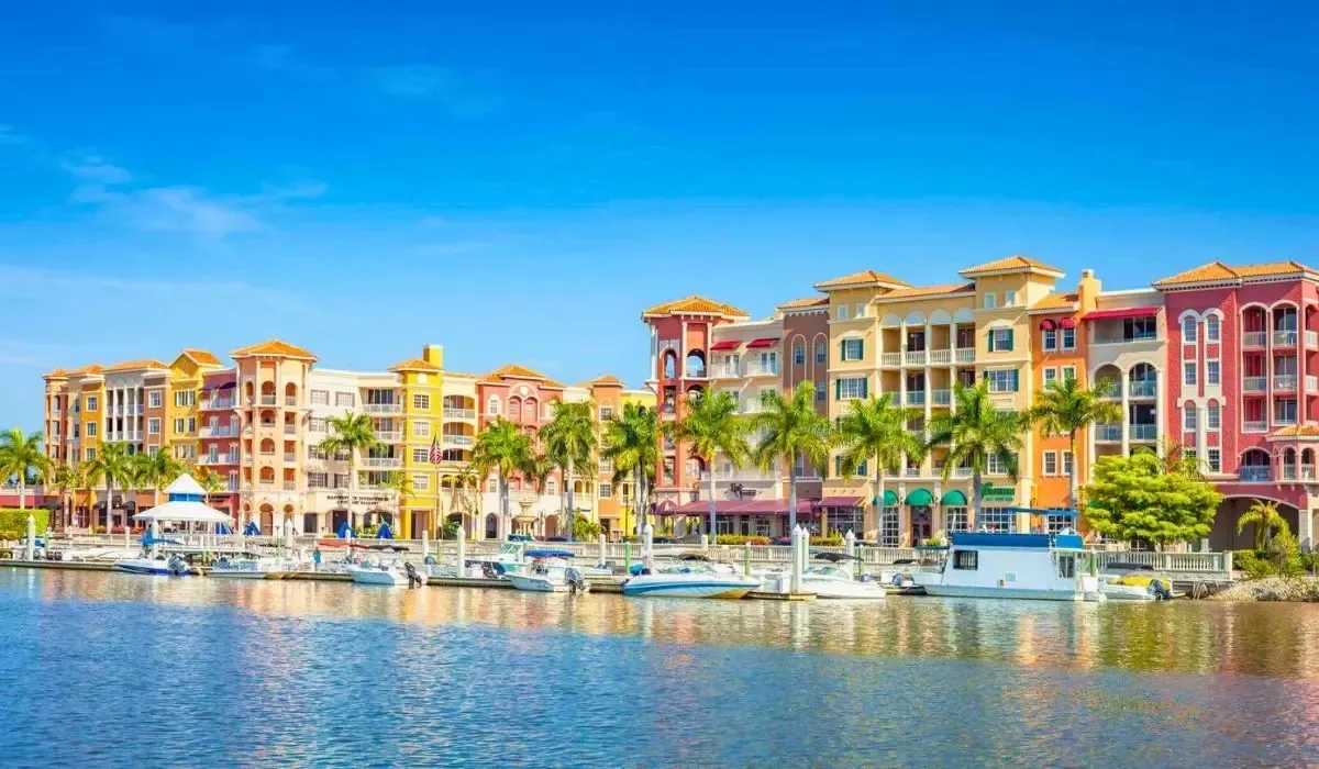 Vibrant waterfront condos and boats in Naples, Florida, appealing to Canadians buying overseas property and navigating CAD to USD exchange rates for transactions.