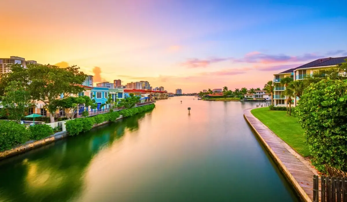 A tranquil scene of Naples' coastline showcasing a sandy beach, gentle waves, and a picturesque sunset.