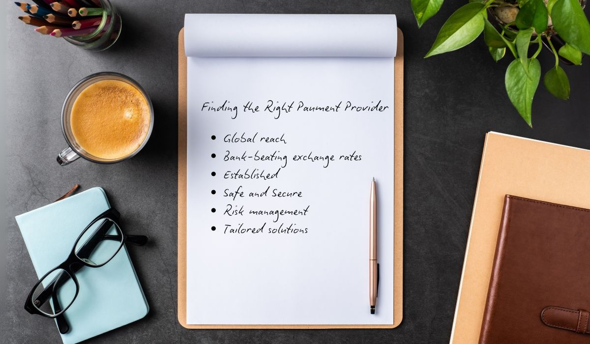Hero image showing a paper and pen on a clipboard with factors that should be considered when choosing the right global payment partner written on it.