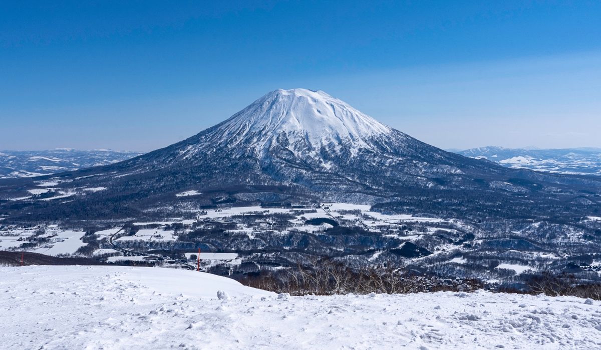 Snow-covered Mount Yotei in Hokkaido, Japan, seen from a ski slope with a panoramic winter landscape.