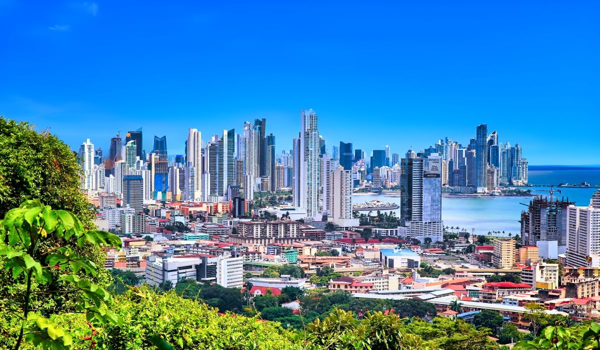 Modern skyline of Panama City with high-rise buildings and oceanfront views under a clear blue sky.