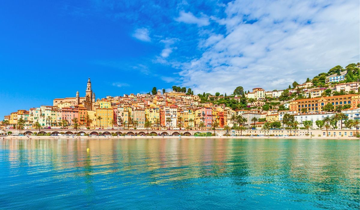 Colorful buildings of Menton, France cascading down a coastal hillside along the French Riviera.