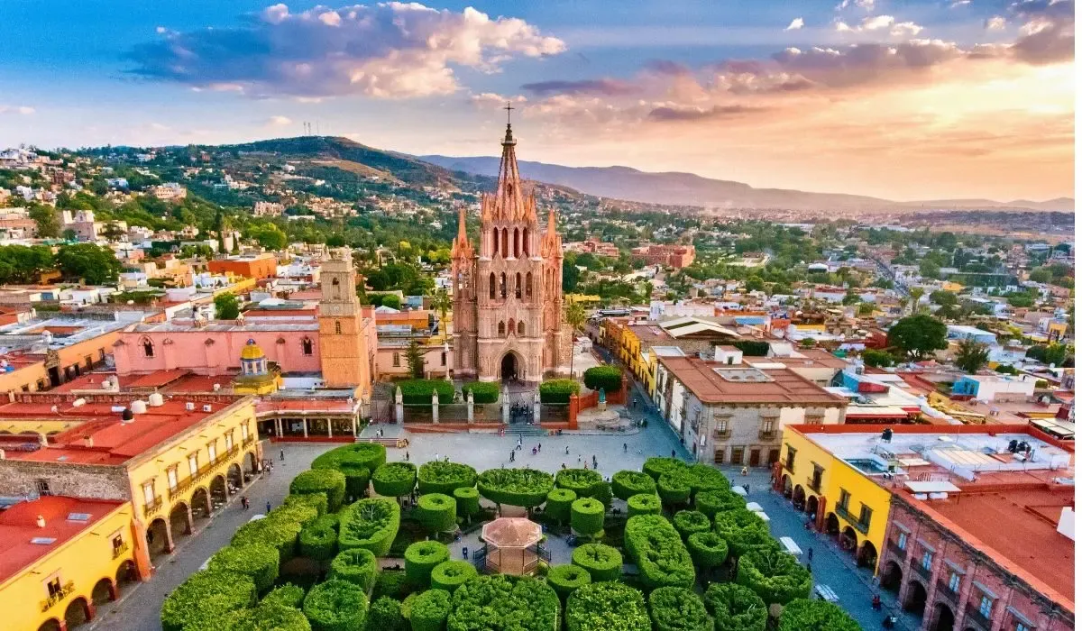 A picturesque view of San Miguel de Allende's historic center, highlighting colorful colonial buildings and the prominent Parroquia de San Miguel Arcángel church.