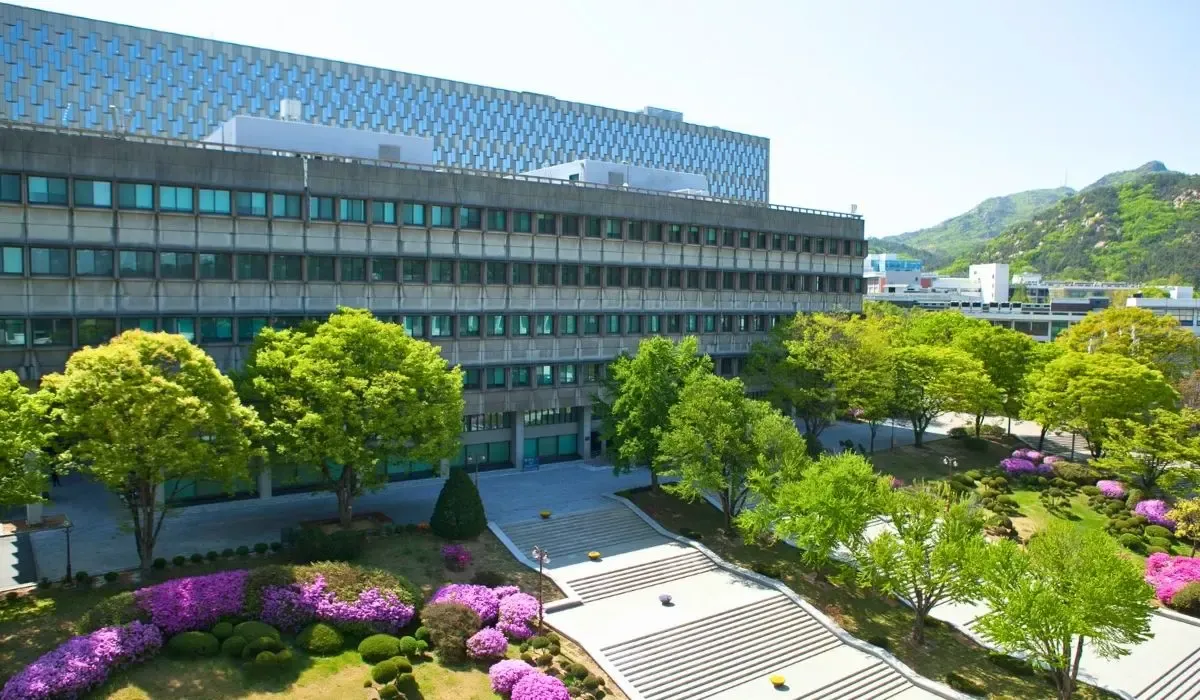 An aerial shot of Seoul National University, highlighting contemporary campus buildings nestled among forested hills.